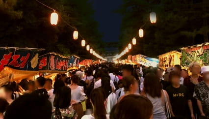 花火大会の観覧エリア、レジャーシートを敷いて座る観客たち