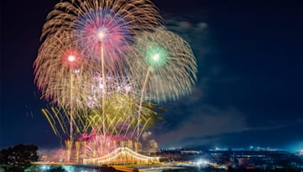 橋とともに打ち上がる色鮮やかな花火、夜空に広がる絶景